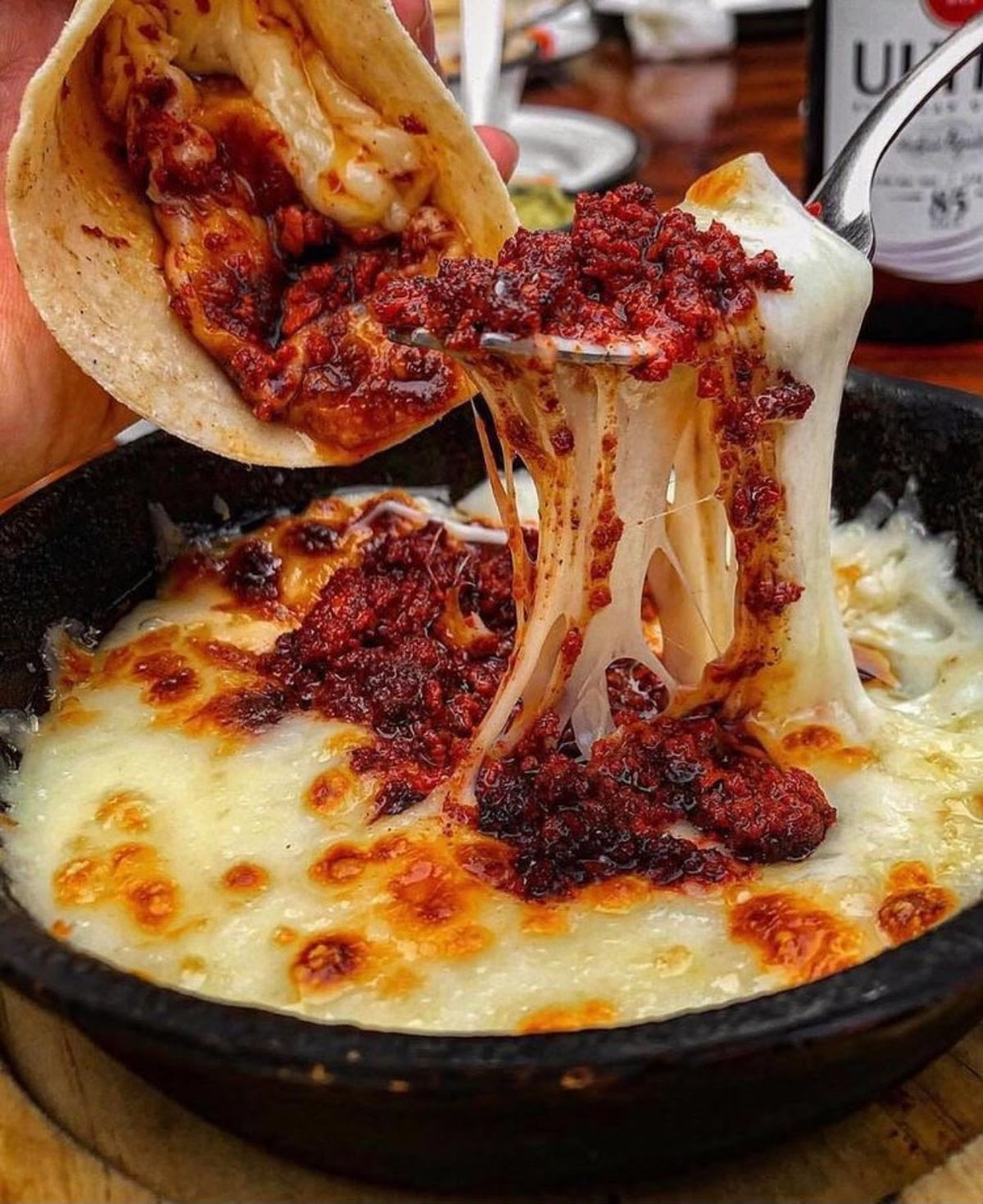 Queso Oaxaca derretido y estirándose sobre un taco
